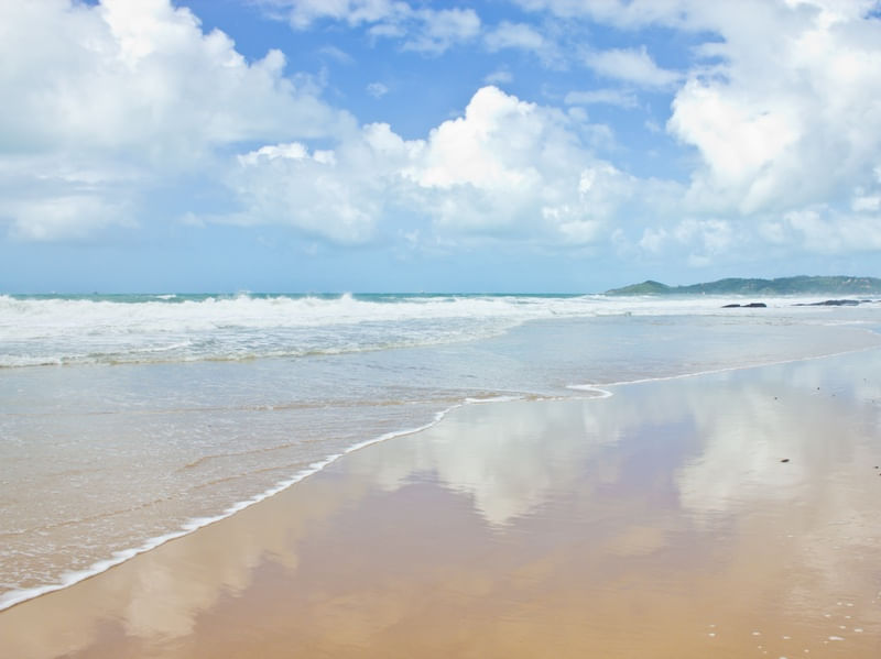 REFLEXO COM ONDAS E NUVENS NA PRAIA
