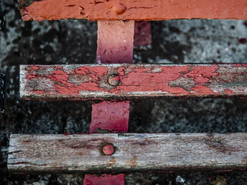 O DETALHE E A TEXTURA DO BANCO VERMELHO DESCASCADO