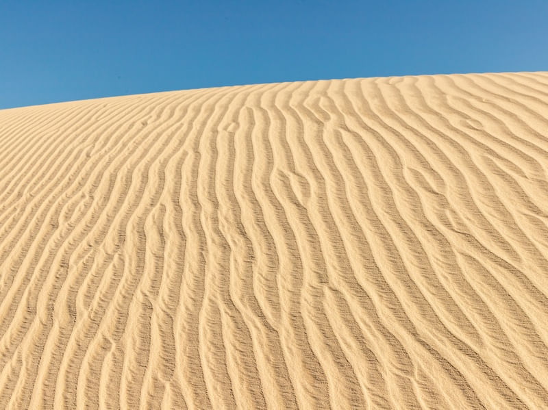 MARCA DE VENTO NAS DUNAS E CÉU AZUL
