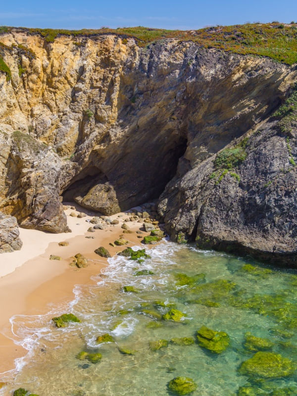 FALÉSIAS E PRAIA DE ÁGUAS CRISTALINAS EM PORTO COVO