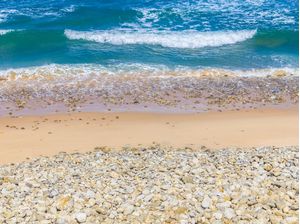 PRAIA COM PEDRAS, AREIA E ONDAS