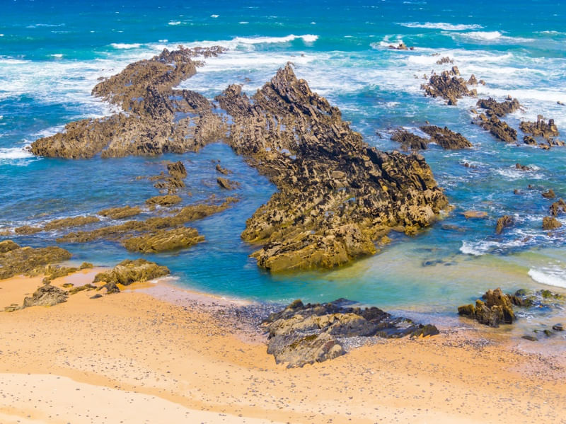 CONJUNTO DE ROCHAS E PEDRAS NA PRAIA