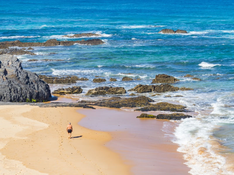 HOMEM CAMINHANDO NA AREIA