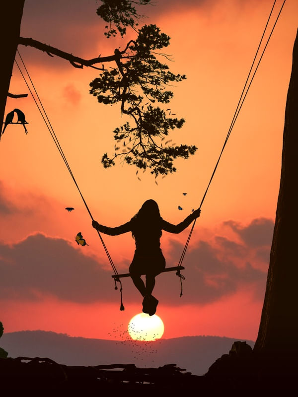 SILHUETA MULHER NO BALANÇO POR DO SOL