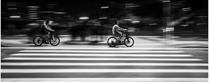 CICLISTAS NA FAIXA DE PEDESTRE EM PRETO E BRANCO