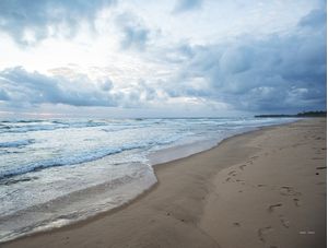 PRAIA DESERTA COM PEGADAS NA AREIA