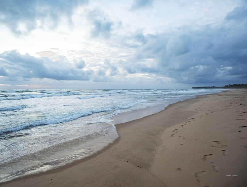 PRAIA DESERTA COM PEGADAS NA AREIA