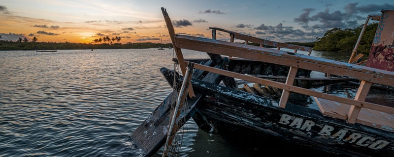 PÔR DO SOL COM BARCO NO MAR COM COQUEIROS