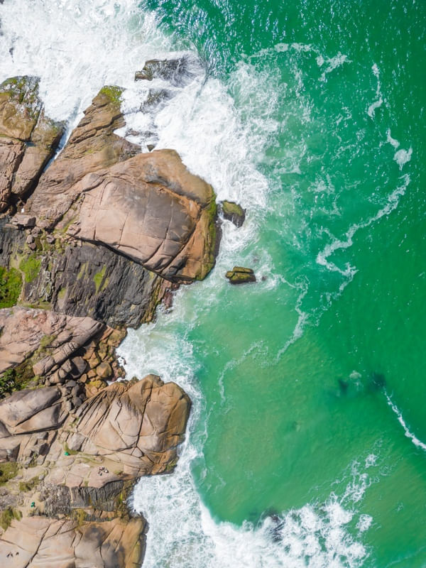 VISTA AÉREA DE ROCHAS E ONDAS NA PRAIA DA JOAQUINA
