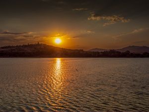 PÔR DO SOL SOBRE MONTANHA E LAGO EM MG