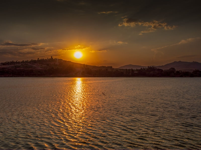 PÔR DO SOL SOBRE MONTANHA E LAGO EM MG