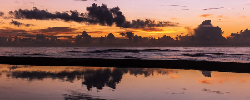 MAR LAGO COM REFLEXO DO SOL NASCENTE