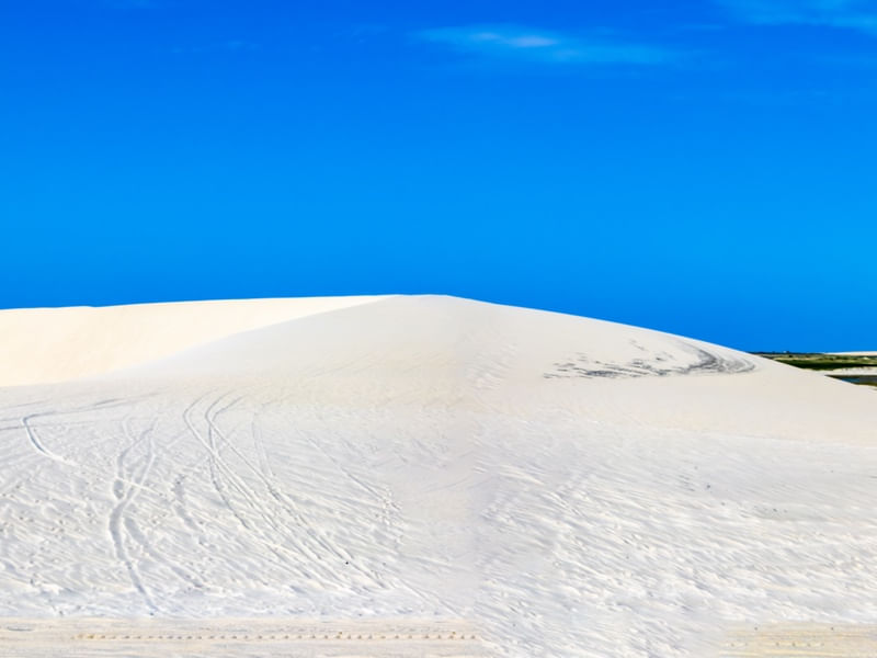 DUNA DE AREIA BRANCA COM CÉU AZUL.