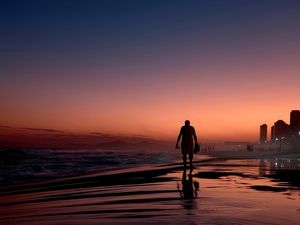 SENHOR CAMINHANDO NA PRAIA DA BARRA DA TIJUCA