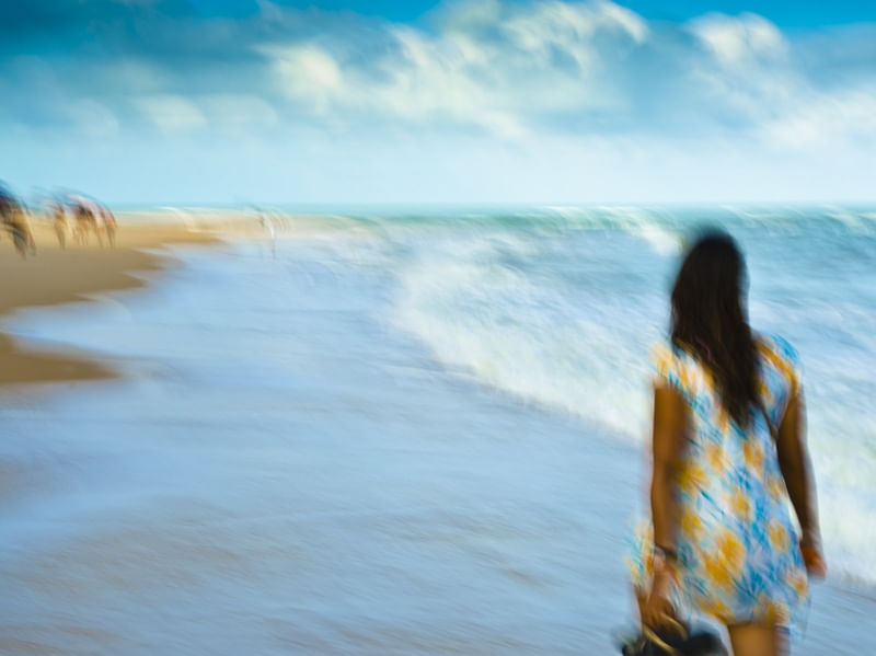 MULHER CAMINHANDO NA PRAIA