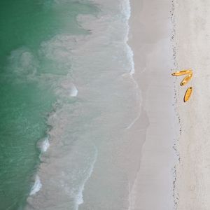 OS CAIAQUES AMARELOS NO MAR ESVERDEADO