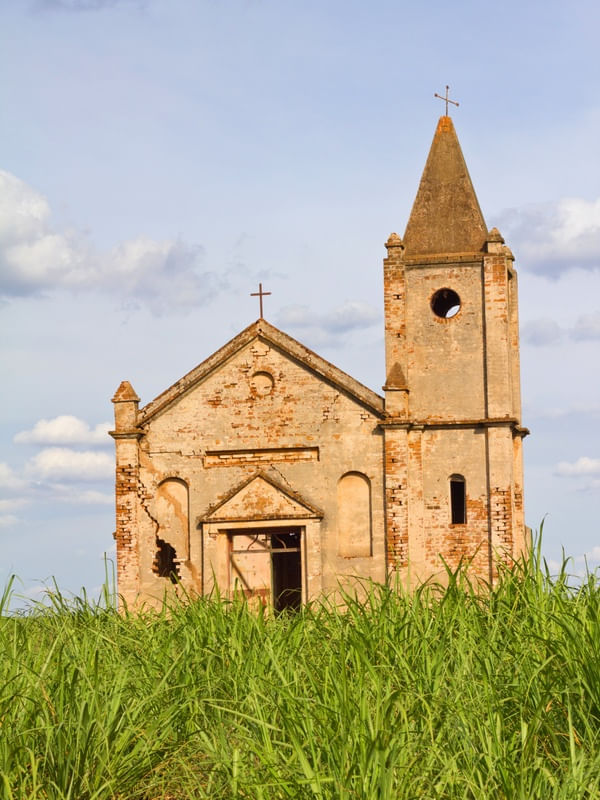 IGREJA ABANDONADA NO CAMPO CERCADA DE VEGETAÇÃO