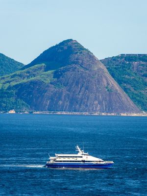MAR DO RIO DE JANEIRO COM BARCO E MONTANHA AO FUNDO