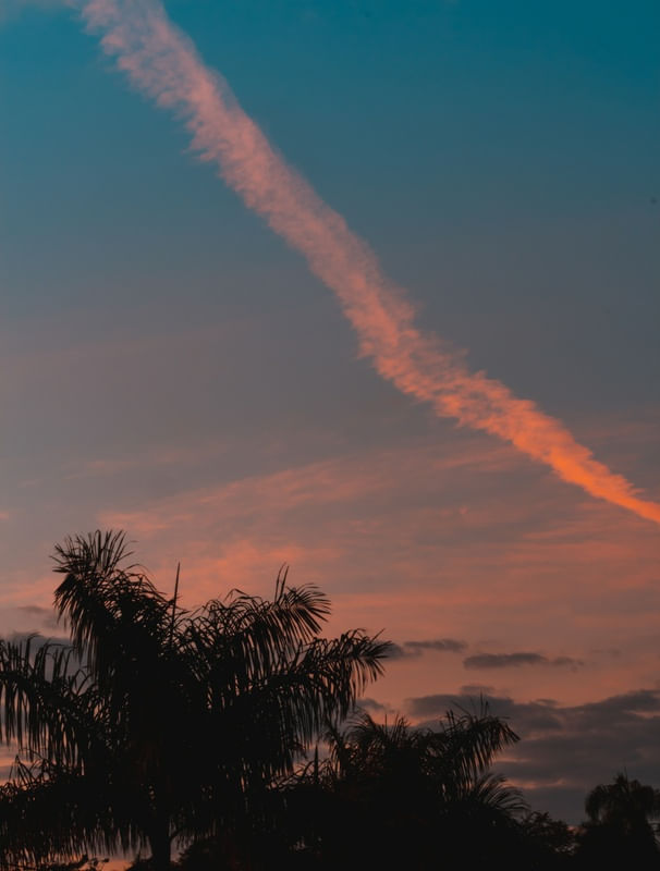 SUNSET AS AN AEROPLANE TRAIL THROUGH THE SKY.