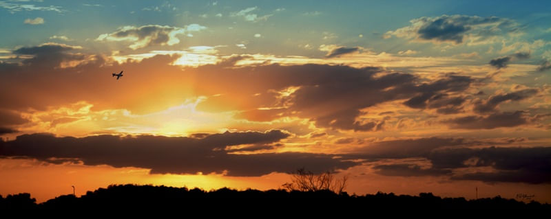 AVIÃO EM CONTRA-LUZ NO CÉU AO PÔR-DO-SOL