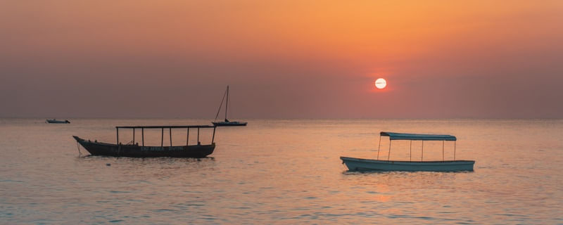 POR DO SOL ALARANJADO E BARCOS