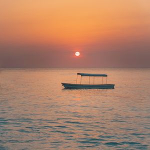 POR DO SOL ALARANJADO E BARCO DE PESCADOR
