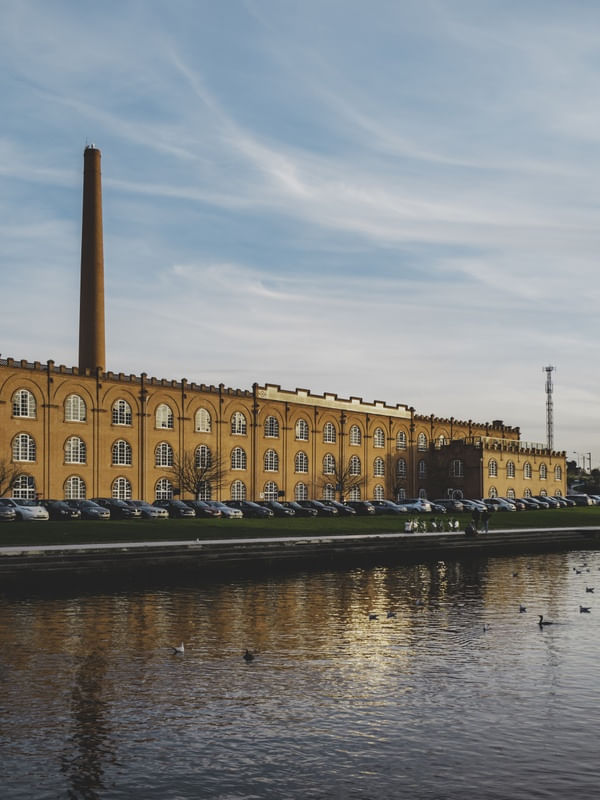 EDIFÍCIO HISTÓRICO DE AVEIRO EM UM DIA ENSOLARADO, REFLETINDO NA RIA