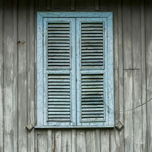 JANELA AZUL EM PAREDE DE MADEIRA