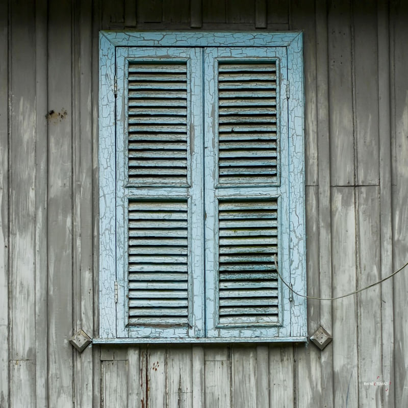 JANELA AZUL EM PAREDE DE MADEIRA