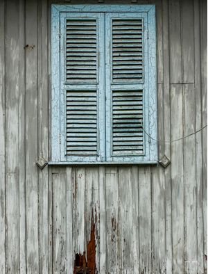 JANELA AZUL EM PAREDE DE MADEIRA DESGASTADA