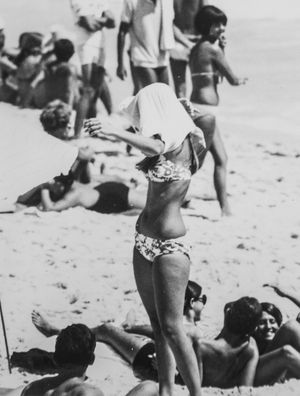 MULHER EM PÉ NA PRAIA 1969
