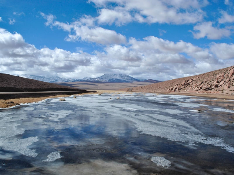 PAISAGEM MONTANHOSA E RIO CONGELADO NO DESERTO DO ATACAMA