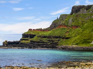 PRAIA COM UMA COLINA AO FUNDO NA IRLANDA DO NORTE