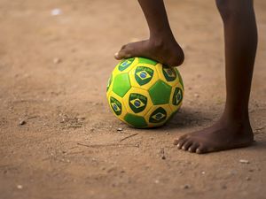 CRIANÇA E SUA BOLA DE FUTEBOL NO RIO DE JANEIRO, BRASIL