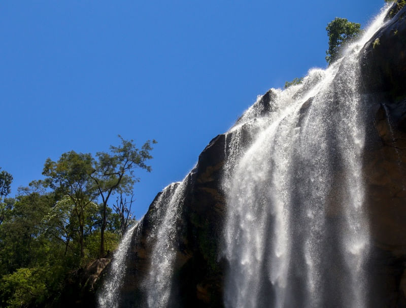 BELA QUEDA D'ÁGUA CONTRASTANDO COM O CÉU AZUL