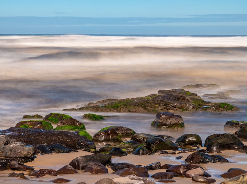 ONDAS EM LONGA EXPOSIÇÃO COM ROCHAS E AREIA