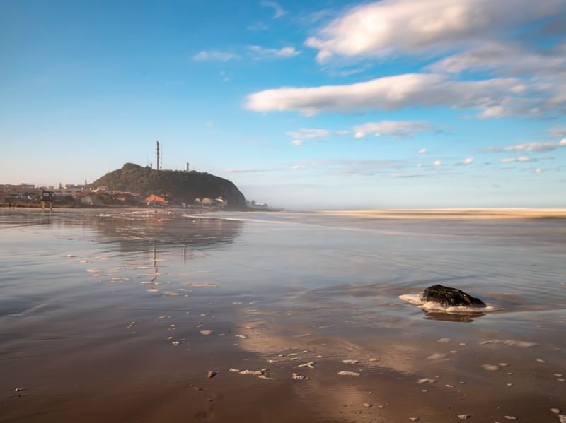 MORRO DO FAROL COM REFLEXO NA PRAIA DO CAL